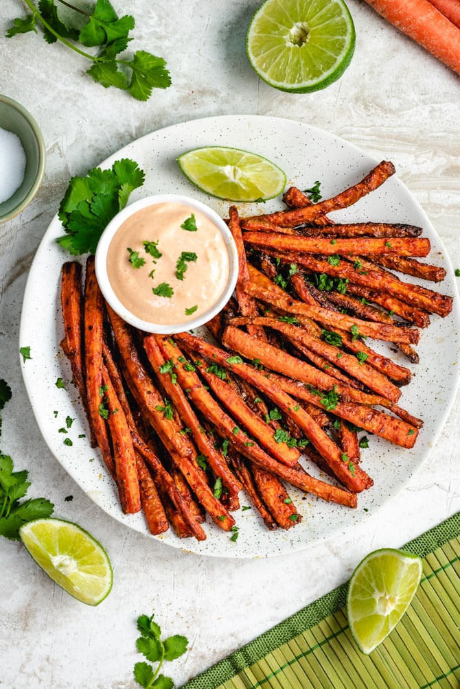 carrots roasted and in the shape of fries on a dish with a sauce